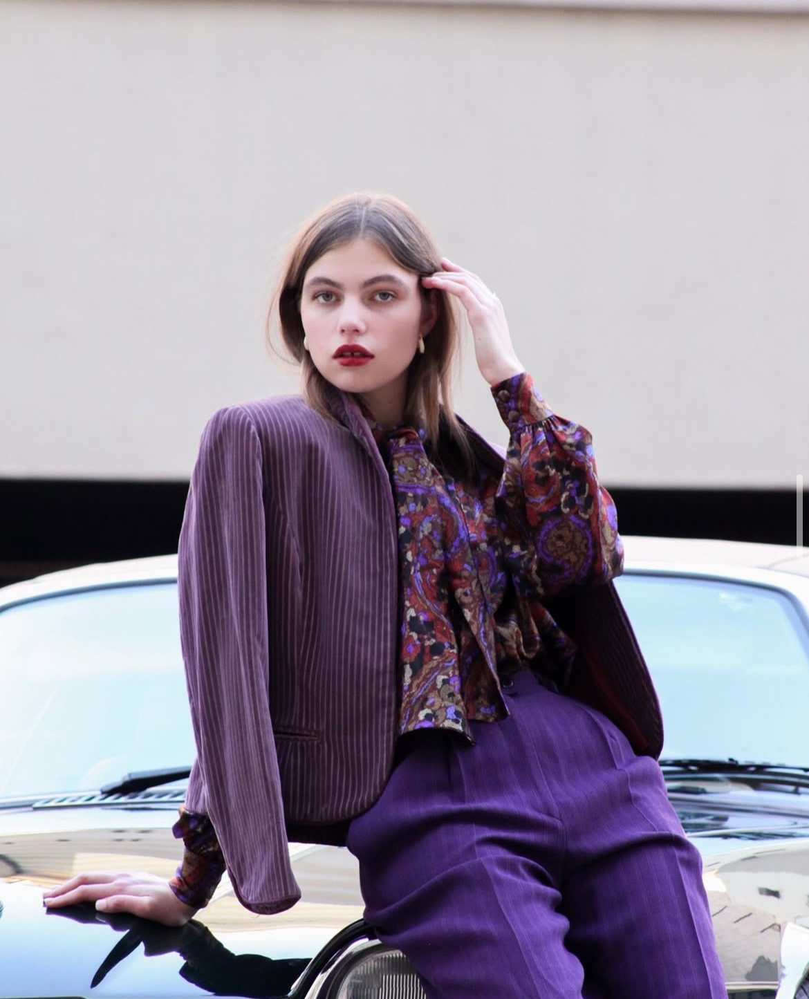 Photo of artist leaning on a car